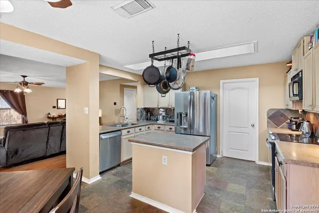 a kitchen with stainless steel appliances granite countertop a sink a stove and refrigerator