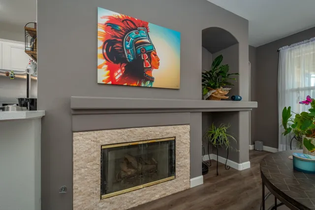 a living room with a painting on the wall and a potted plant