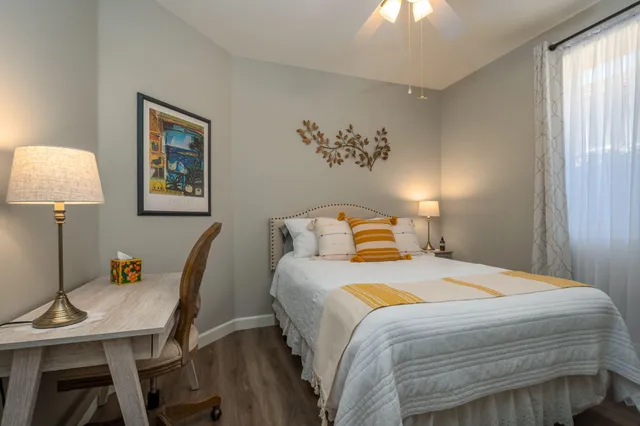 a bedroom with a bed and a lamp on dresser