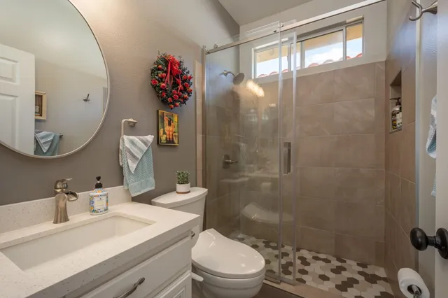 a bathroom with a sink mirror toilet and shower