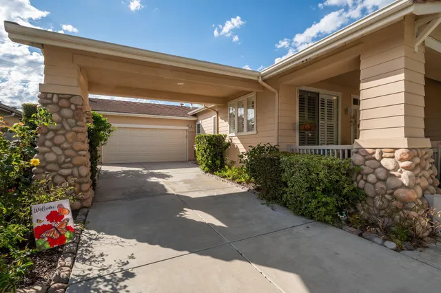 a front view of a house with plants