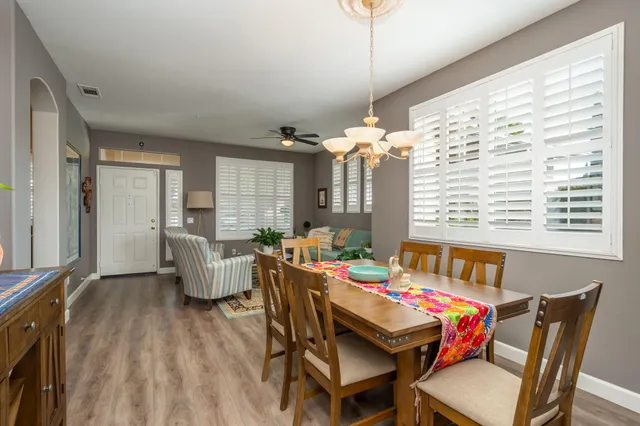 a dining room with furniture a chandelier and wooden floor