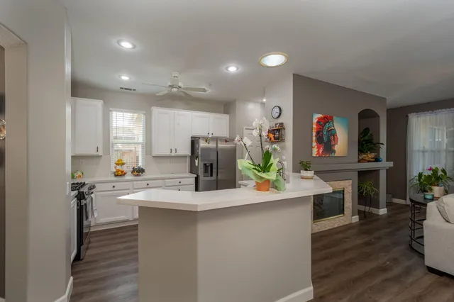a kitchen with kitchen island white cabinets and stainless steel appliances