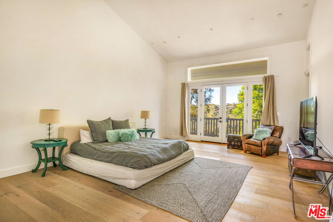 9669 Oak Pass Road Beverly Hills, CA 90210 - Photo 20 of 37 a bedroom with a bed and large window