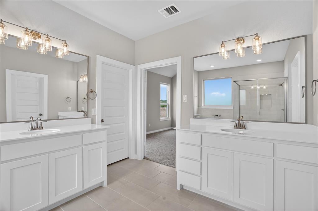 504 Clifton Court Springtown, TX 76082 - Photo 32 of 36 Dual vanities featuring white cabinetry, integrated sinks, and polished chrome fixtures