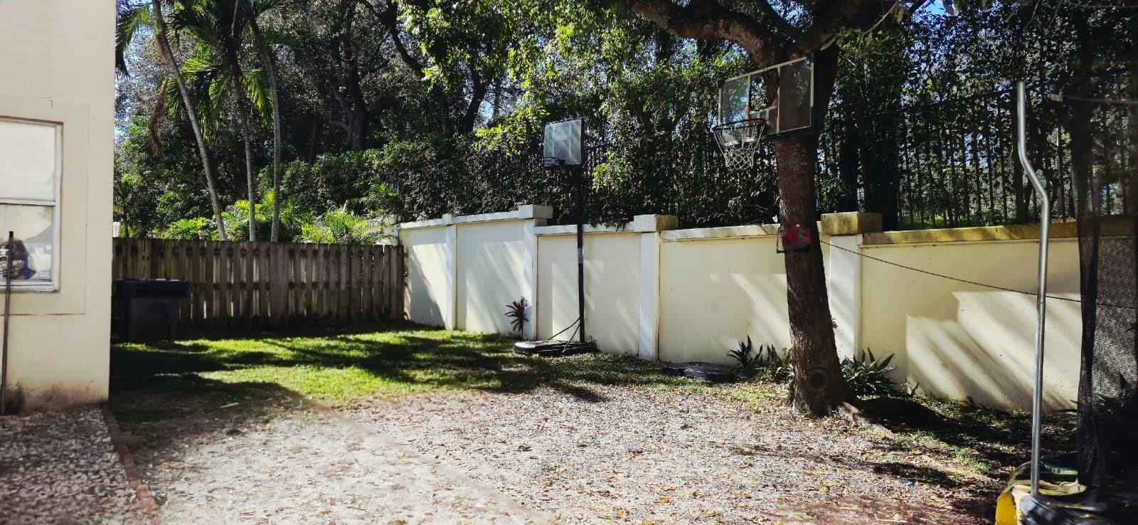 1888 Northwest 75th Way Hollywood, FL 33024 - Photo 6 of 45 a backyard of a house with large trees and wooden fence