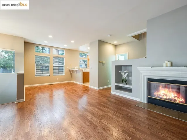a view of an empty room with a fireplace and a window