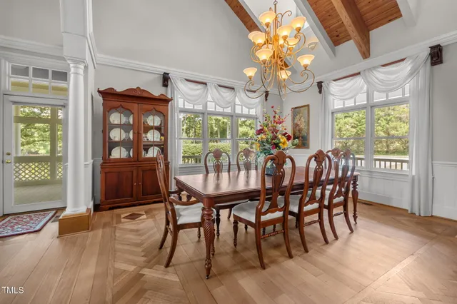a dining room with furniture a chandelier and wooden floor