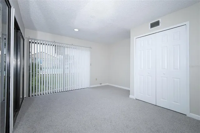 an empty room with closet and entryway