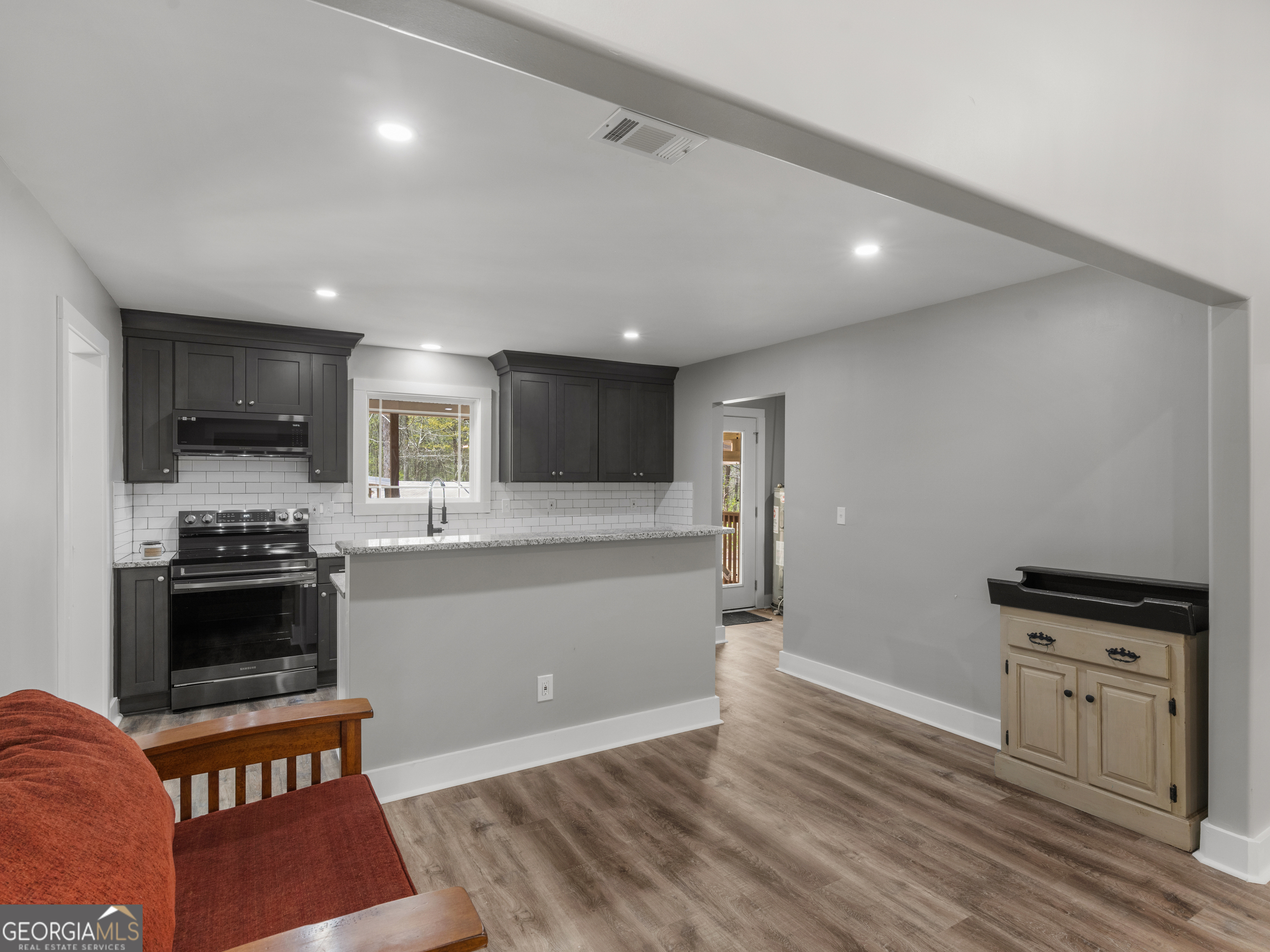 265 Steele Road Griffin, GA 30223 - Photo 11 of 64 a kitchen with stainless steel appliances kitchen island granite countertop a refrigerator and a stove top oven with wooden floor