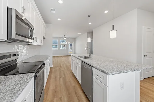 a kitchen with stainless steel appliances granite countertop a sink stove and microwave