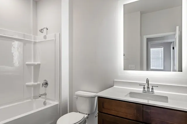 a bathroom with a sink toilet vanity and shower
