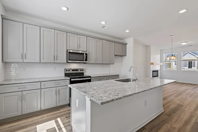 a kitchen with granite countertop a sink and white cabinets