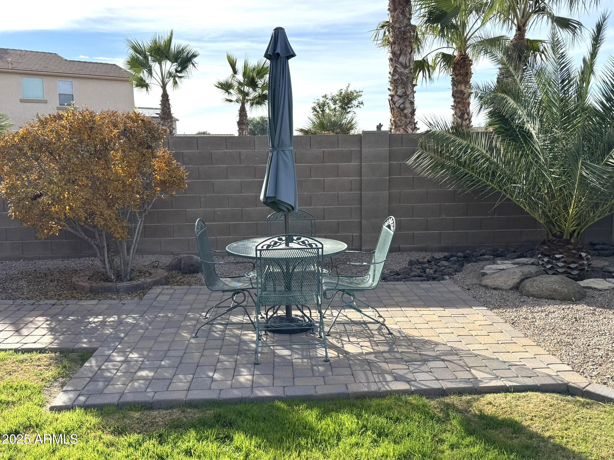 19078 North Lariat Road Maricopa, AZ 85138 - Photo 29 of 30 a view of a backyard with table and chairs potted plants and palm tree