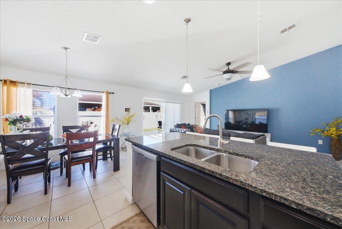 3258 Olivera Way St. Cloud, FL 34772 - Photo 14 of 30 a kitchen with granite countertop sink table and chairs