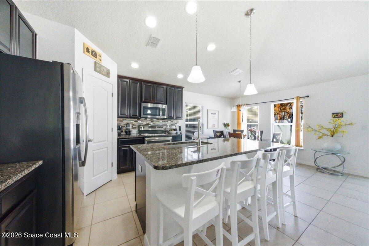 3258 Olivera Way St. Cloud, FL 34772 - Photo 15 of 30 a large kitchen with kitchen island a large counter top stainless steel appliances and cabinets