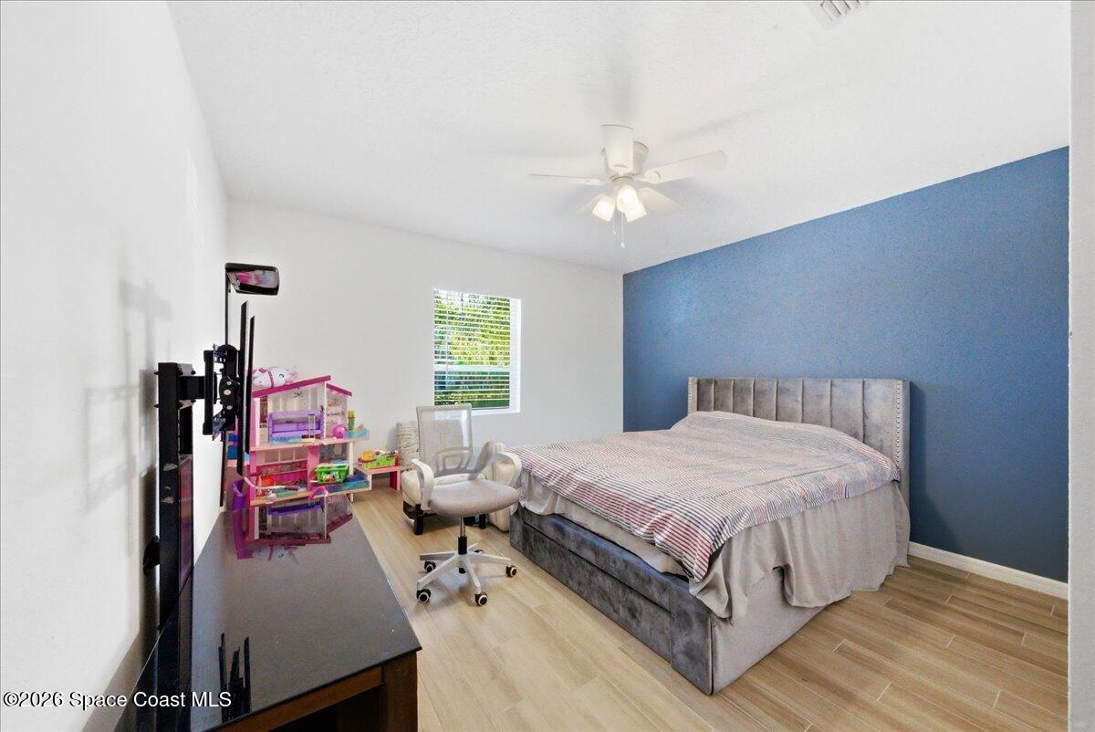 3258 Olivera Way St. Cloud, FL 34772 - Photo 22 of 30 a bed room with a bed window and a chandelier