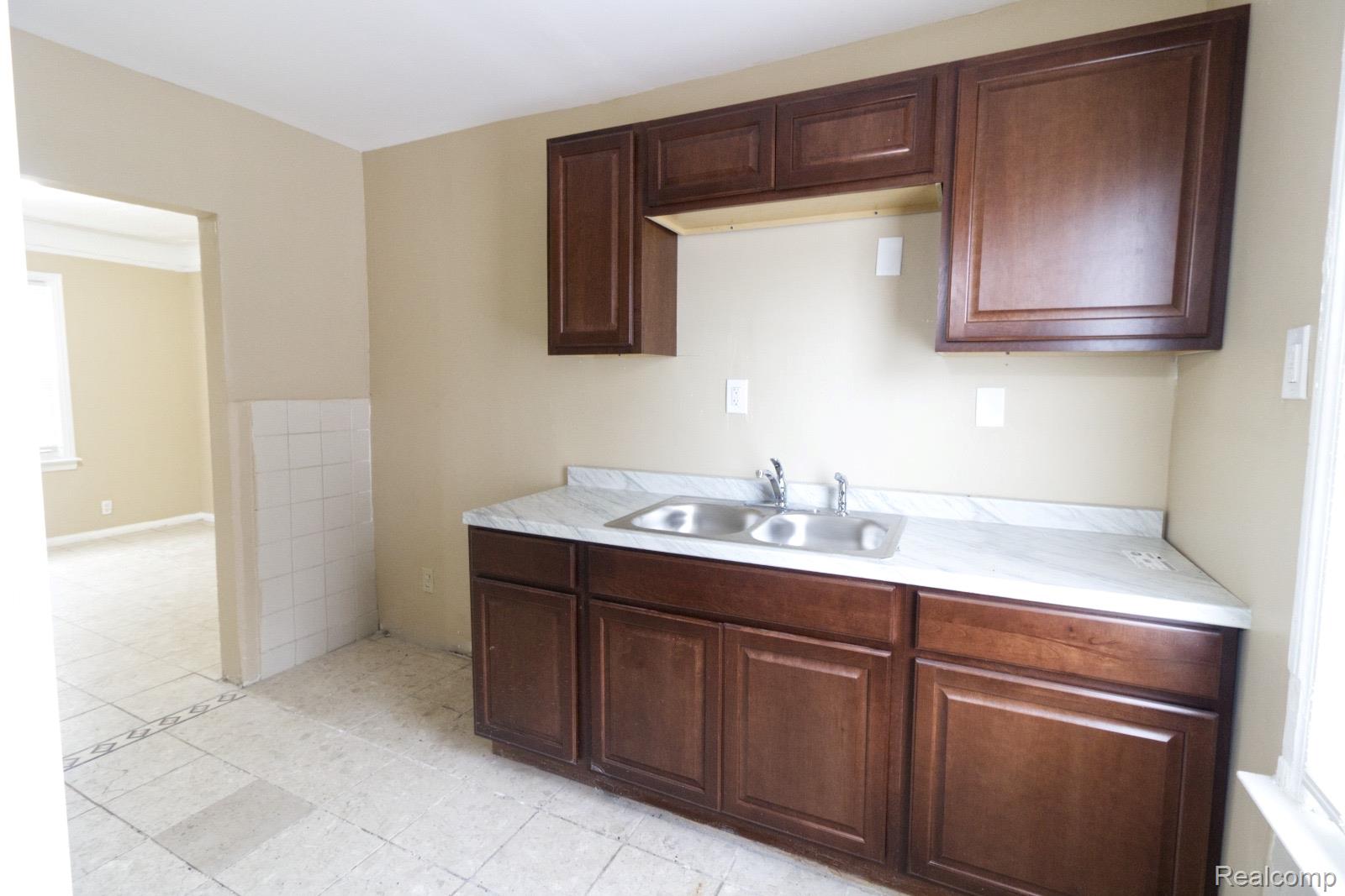 8096 Chamberlain Street Detroit, MI 48209 - Photo 8 of 10 Kitchen featuring light countertops, dark wood finish cabinets, and light tile patterned floors