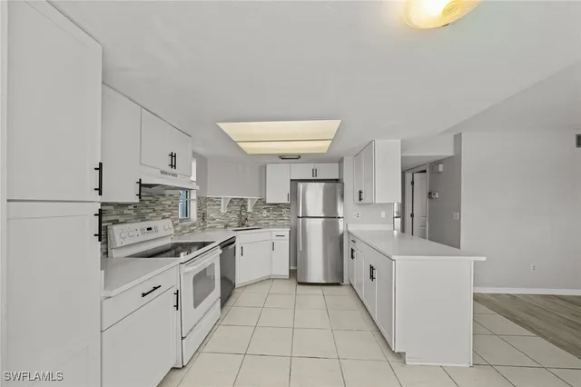 a kitchen with white cabinets and white appliances