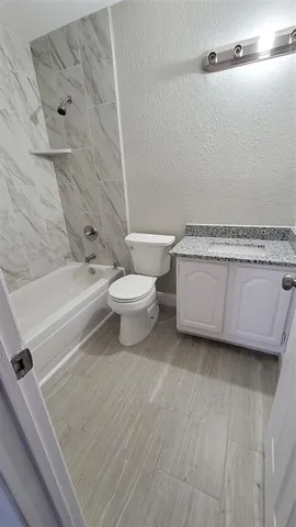 a bathroom with a toilet a sink and bathtub