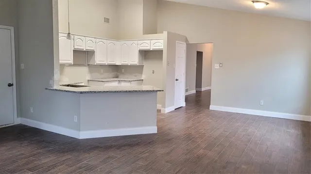 a view of a kitchen with wooden floor and a sink