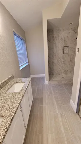 a bathroom with a granite countertop sink and washing machine