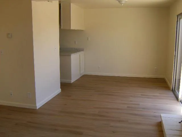a view of an empty room with wooden floor