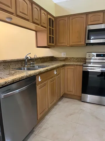 a kitchen with stainless steel appliances granite countertop a stove a sink and a microwave