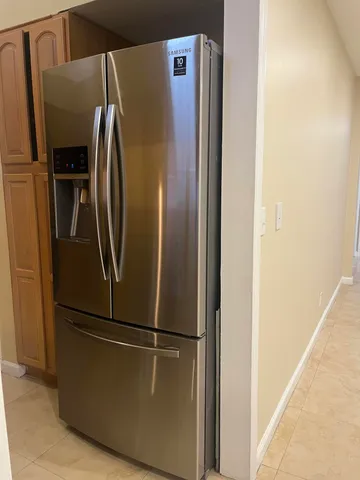 a metallic refrigerator freezer sitting in a kitchen
