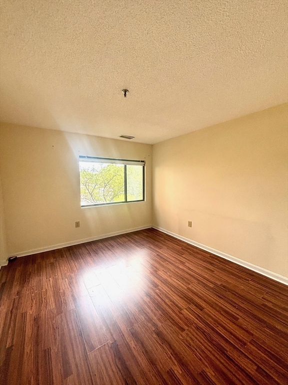 3920 Mystic Valley Parkway, Unit 115 Medford, MA 02155 - Photo 14 of 27 an empty room with wooden floor and windows