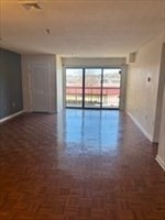 3920 Mystic Valley Parkway, Unit 115 Medford, MA 02155 - Photo 3 of 27 an empty room with wooden floor and windows