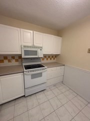 3920 Mystic Valley Parkway, Unit 115 Medford, MA 02155 - Photo 9 of 27 a kitchen with white cabinets and white appliances