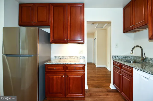 a kitchen with granite countertop stainless steel appliances and wooden cabinets
