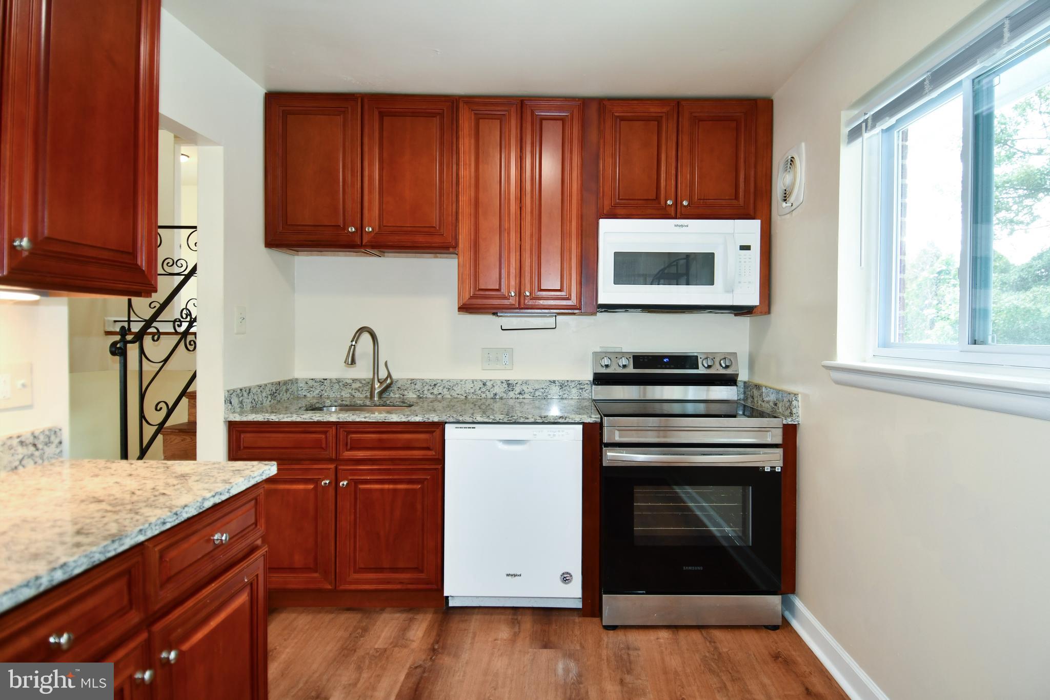 10304 Inwood Avenue Silver Spring, MD 20902 - Photo 7 of 24 a kitchen with granite countertop wooden cabinets and a stove top oven
