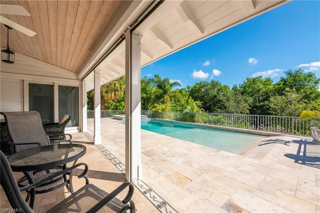 a view of a patio with a table chairs and a backyard