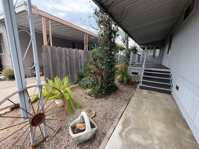 a backyard with potted plants and a wooden bench