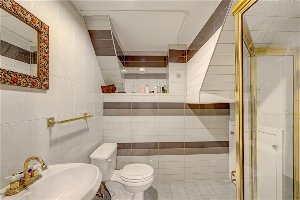1262 East 73rd Street Brooklyn, NY 11234 - Photo 24 of 26 a bathroom with a sink a toilet and a mirror