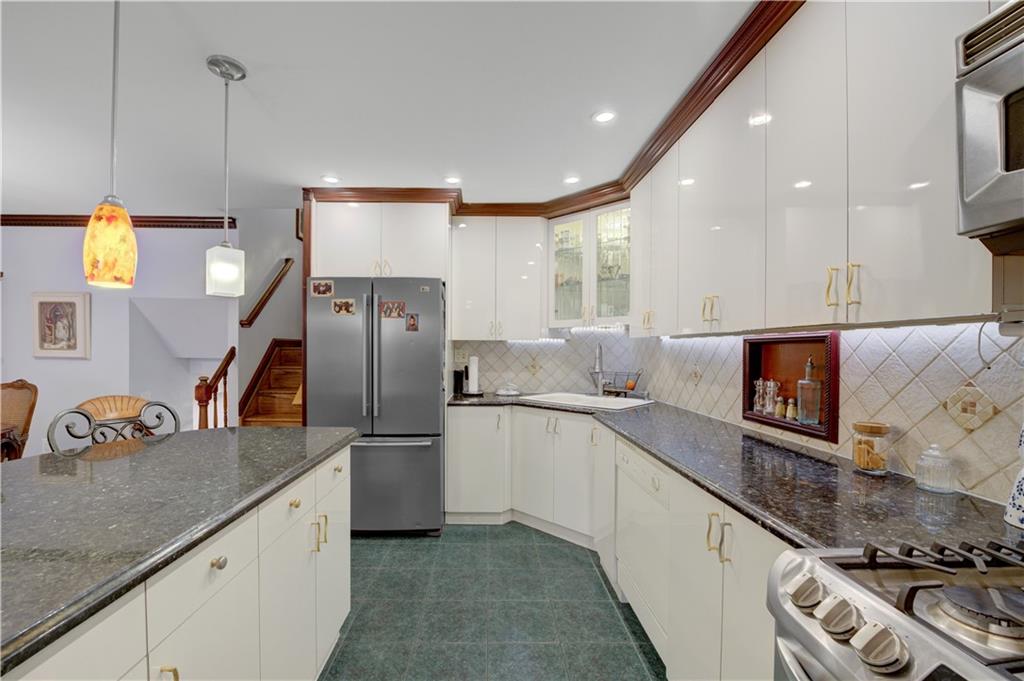 1262 East 73rd Street Brooklyn, NY 11234 - Photo 4 of 26 a kitchen with stainless steel appliances granite countertop a sink and a refrigerator