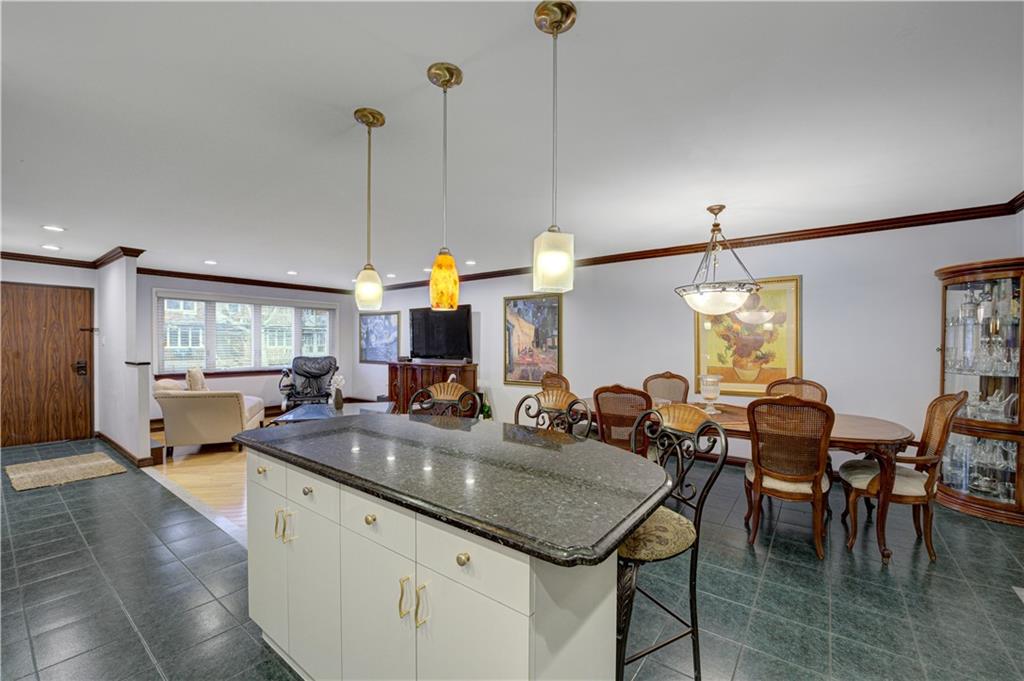 1262 East 73rd Street Brooklyn, NY 11234 - Photo 5 of 26 a kitchen with center island table and chairs in it