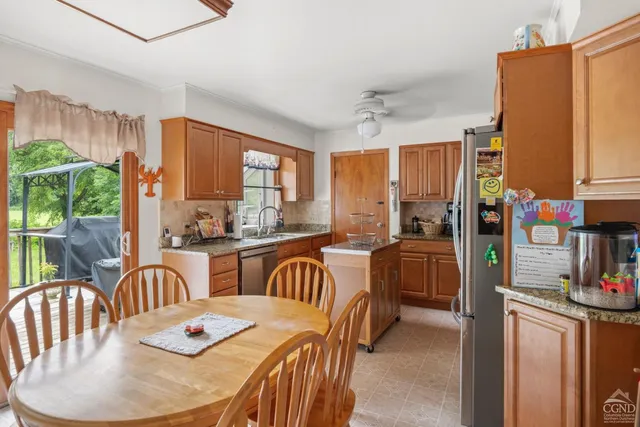 a dining room with furniture a large window and kitchen view