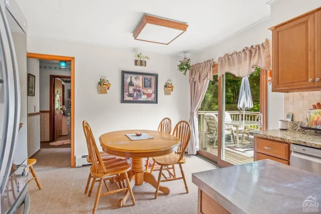 a dining room with furniture a flat screen tv and a large window
