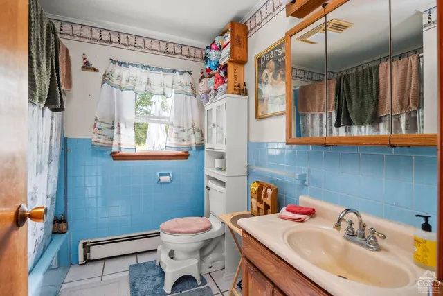 a bathroom with a sink a toilet and shower curtain