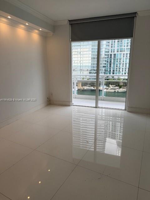 901 Brickell Key Boulevard, Unit 906 Miami, FL 33131 - Photo 21 of 60 a view of empty room with wooden floor and fan
