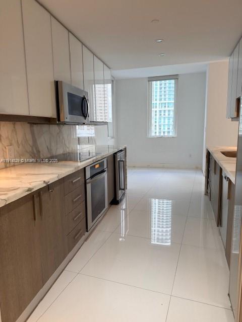 901 Brickell Key Boulevard, Unit 906 Miami, FL 33131 - Photo 24 of 60 a kitchen with stainless steel appliances granite countertop a sink and a stove top oven