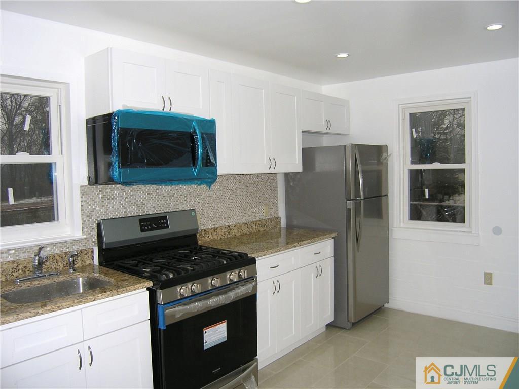 20 Pennington Road New Brunswick, NJ 08901 - Photo 3 of 15 a kitchen with stainless steel appliances granite countertop a stove microwave and refrigerator