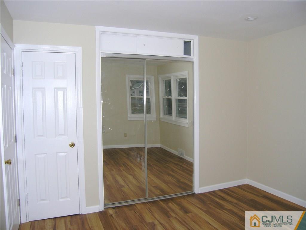 20 Pennington Road New Brunswick, NJ 08901 - Photo 4 of 15 an empty room with wooden floor and cabinet