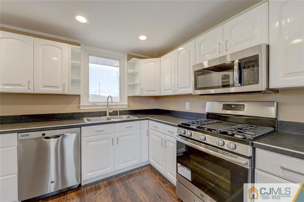 202 Higgins Road Old Bridge, NJ 07747 - Photo 12 of 25 a kitchen with granite countertop white cabinets and appliances