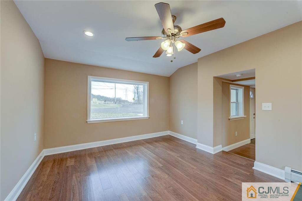 202 Higgins Road Old Bridge, NJ 07747 - Photo 14 of 25 a view of an empty room with wooden floor and a window