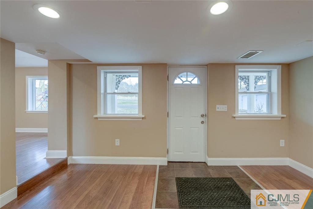 202 Higgins Road Old Bridge, NJ 07747 - Photo 15 of 25 a view of an empty room with window and wooden floor