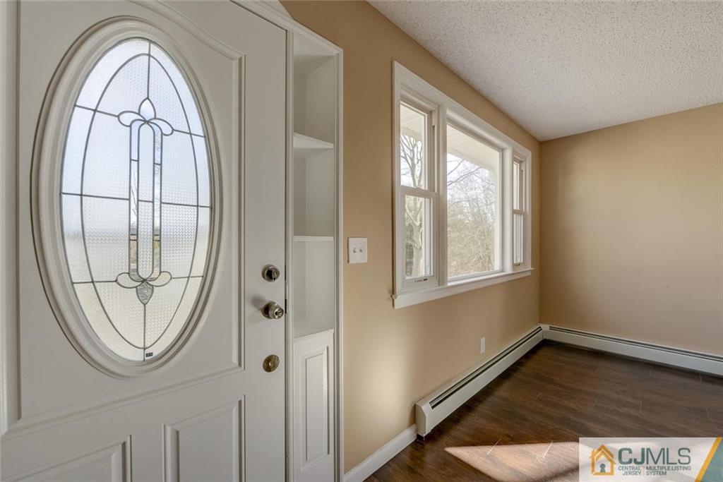 202 Higgins Road Old Bridge, NJ 07747 - Photo 3 of 25 an empty room with wooden floor fan and windows